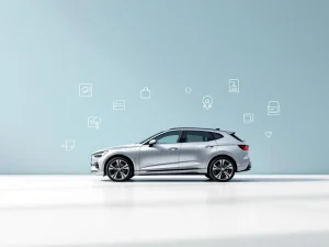 Zilverkleurige zakenauto op witte ondergrond omringd door leasingsymbolen zoals sleutels en documenten op blauwe achtergrond