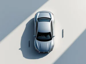 Zilveren zakenauto van bovenaf met calculator en pen op witte ondergrond voor lease berekeningen
