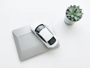 Witte elektrische auto op minimalistische weegschaal met groene plant op neutrale achtergrond