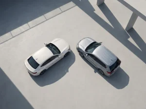 Witte elektrische auto en zilveren plug-in hybride voertuig op betonnen oppervlak met zichtbare oplaadpoorten