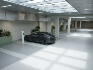 Elektrische auto laadt bij wit laadstation in moderne bedrijfsgarage met geometrische lijnen en natuurlijk licht