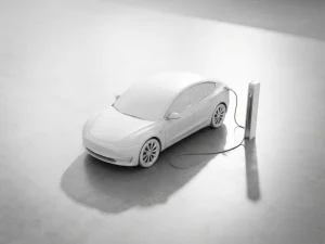 Witte elektrische auto aangesloten op minimalistische laadpaal op betonnen ondergrond met geometrische schaduwen