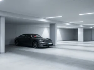 Elektrische auto met lege batterij-indicator in moderne minimalistische parkeergarage met witte betonnen wanden