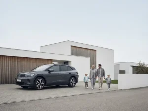 Moderne elektrische SUV in oprit met gezin van vier personen lopend naar voertuig, minimalistische architectuur op achtergrond