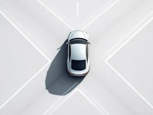 Zilverkleurige zakenauto op kruispunt met meerdere wegen, bovenaanzicht symboliseert bedrijfskeuzes en besluitvorming